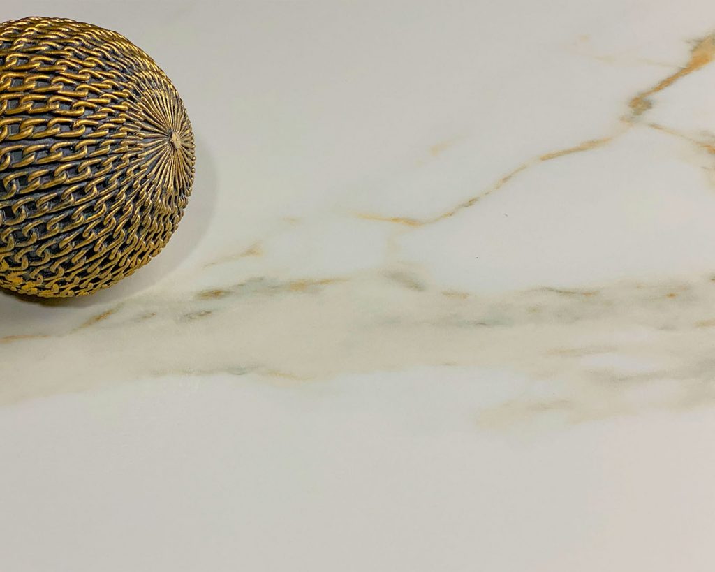 Copertina collezione Marmi Pregiati Calacatta con pallina decorata in oro per accedere alla pagina della serie